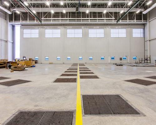 Interior of Lufthansa Technik Heavy Maintenance Facility. Large open space with white walls and bright lighting.